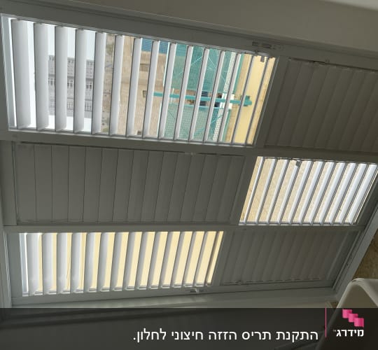 תריסי אלומיניום לבנים בחלון גדול